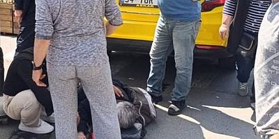 Geri geri giden taksi, yaşlı kadını altına aldı