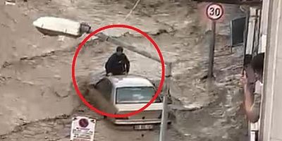 Sel sularına kapılan aracın üzerinde hayata tutundu