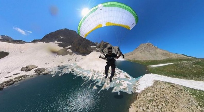 Donmuş gölün üzerinde kayak, gökyüzünde paraşüt