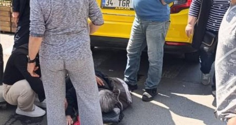 Geri geri giden taksi, yaşlı kadını altına aldı