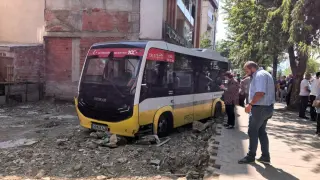 Minibüs, iş yerine çarptıktan sonra boş arsaya uçtu